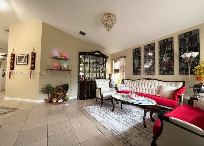 21316 Southwest 87th Place Cutler Bay, FL 33189 - Photo 7 of 14 a living room with furniture a rug and a chandelier
