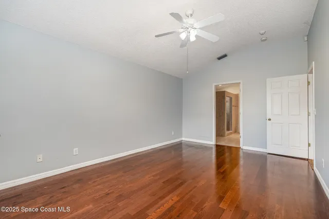 a view of an empty room with wooden floor