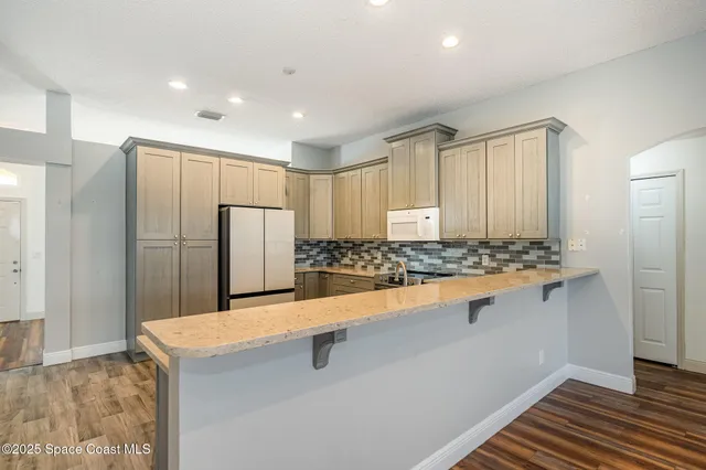 a kitchen with stainless steel appliances granite countertop a refrigerator and a stove