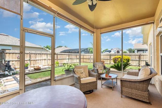 a living room with furniture and a floor to ceiling window