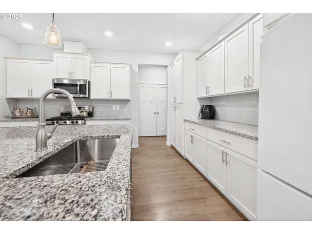 a open kitchen with kitchen island granite countertop a sink cabinets and stainless steel appliances