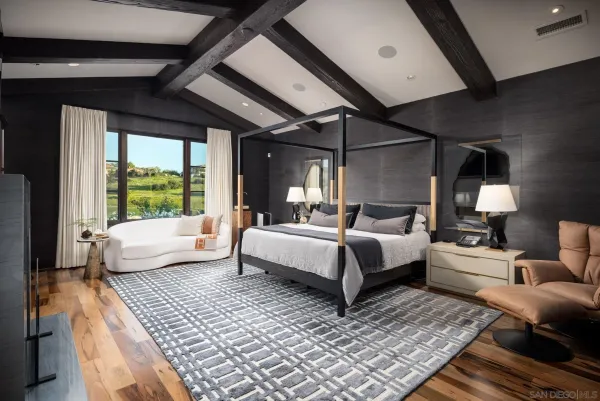 a bedroom with furniture and a large window