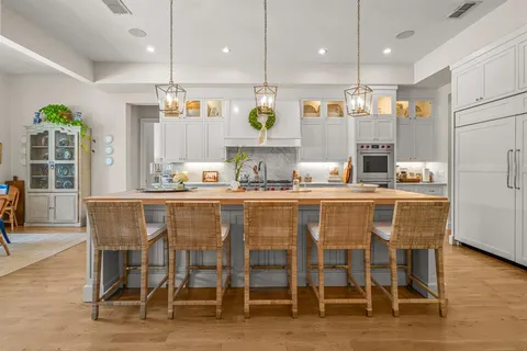 a room with stainless steel appliances kitchen island granite countertop a table and chairs in it
