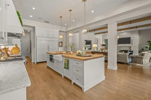 a large kitchen with stainless steel appliances kitchen island granite countertop a large counter top and a stove