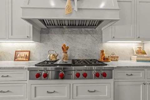 a kitchen with white cabinets and appliances