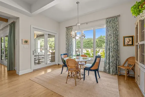 a view of a dining room with furniture large windows and wooden floor
