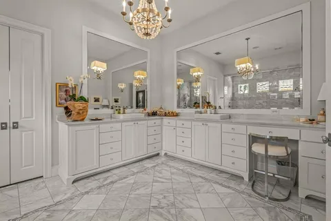 a spacious en suite bathroom with a granite countertop sink mirror and