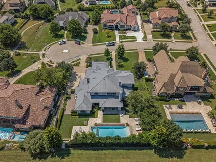 an aerial view of residential houses with outdoor space and parking