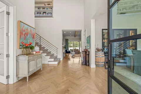 a hallway with white cabinets and chandelier