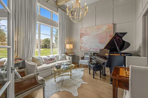 a living room with furniture a fireplace and a chandelier