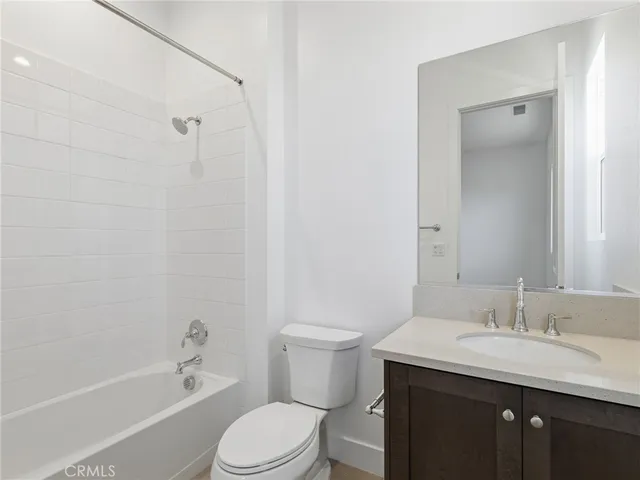 a bathroom with a granite countertop sink a toilet and shower