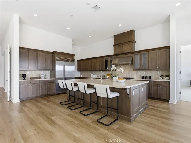 a kitchen with stainless steel appliances kitchen island granite countertop a sink cabinets and wooden floor