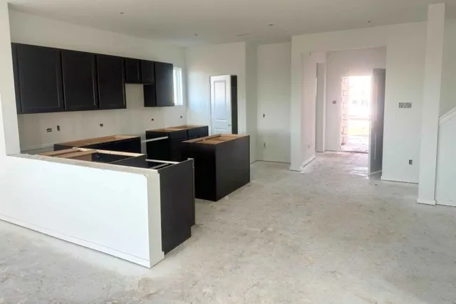 a kitchen with stainless steel appliances a stove a microwave a sink a refrigerator and cabinets