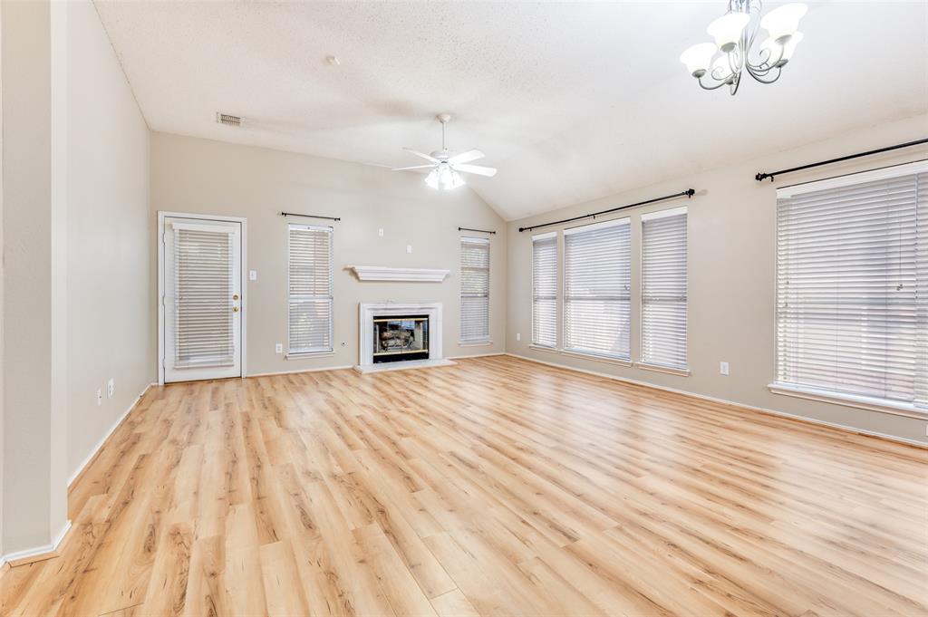 4921 Tulip Lane Fort Worth, TX 76137 - Photo 3 of 12 an empty room with wooden floor fireplace and windows