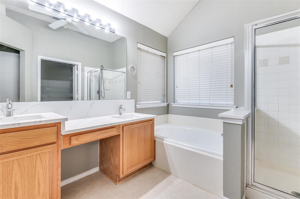 4921 Tulip Lane Fort Worth, TX 76137 - Photo 9 of 12 a bathroom with a tub a sink and a mirror
