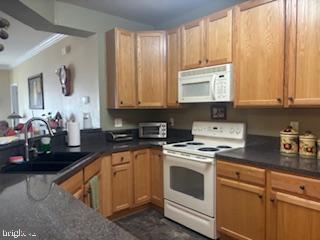 700 Cattail Cove, Unit 207 Cambridge, MD 21613 - Photo 12 of 29 a kitchen with granite countertop white cabinets and white appliances
