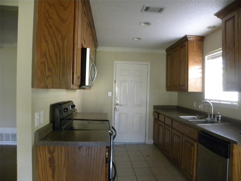 a kitchen with a sink a microwave and cabinets