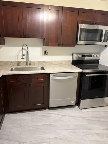a kitchen with stainless steel appliances granite countertop a sink and a microwave