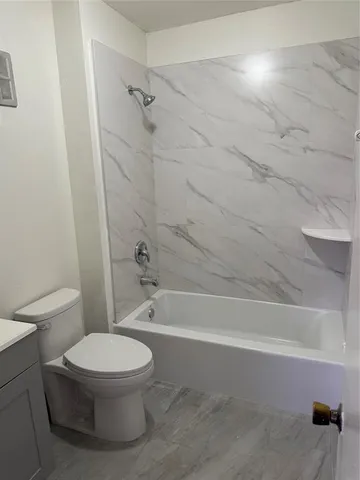 a white toilet and tub sitting next to a bathroom sink
