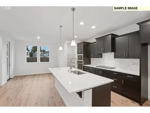 a kitchen with kitchen island a sink appliances and a counter top space