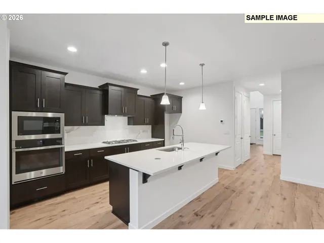 a kitchen with kitchen island a sink stainless steel appliances and cabinets