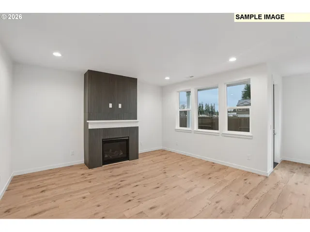 a view of an empty room with a fireplace and a window