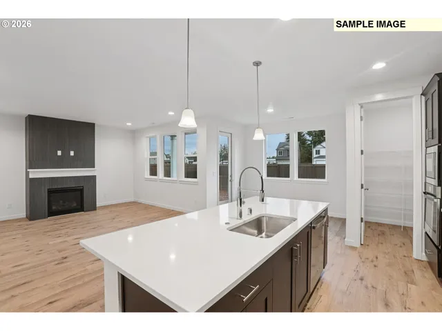 a kitchen with a sink a center island and stainless steel appliances