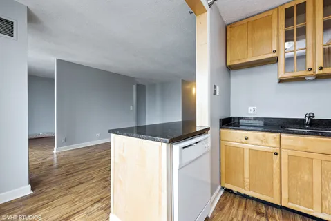 a kitchen with stainless steel appliances granite countertop a sink and cabinets with wooden floor