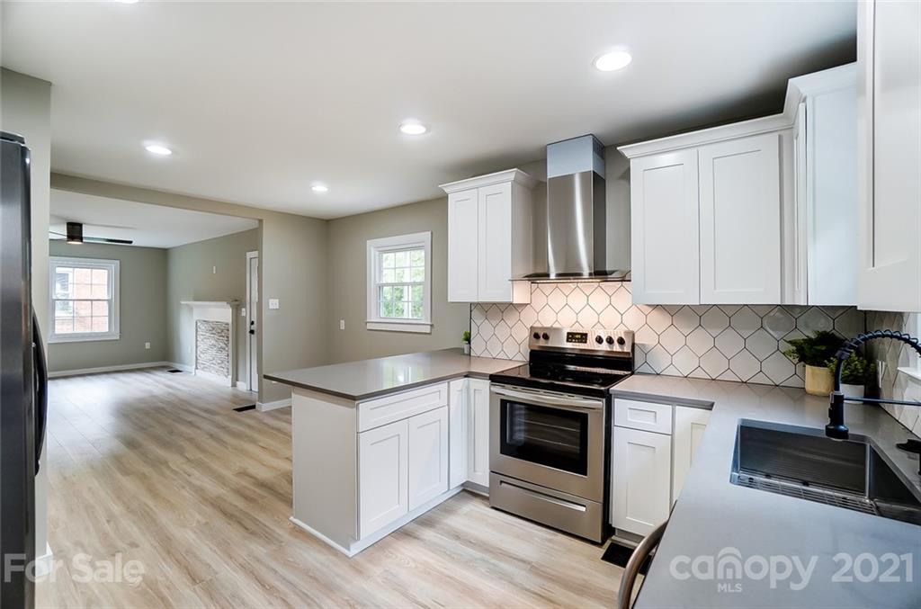 2305 Remount Road Charlotte, NC 28208 - Photo 3 of 31 a kitchen with stainless steel appliances granite countertop a stove top oven a sink dishwasher and white cabinets with wooden floor