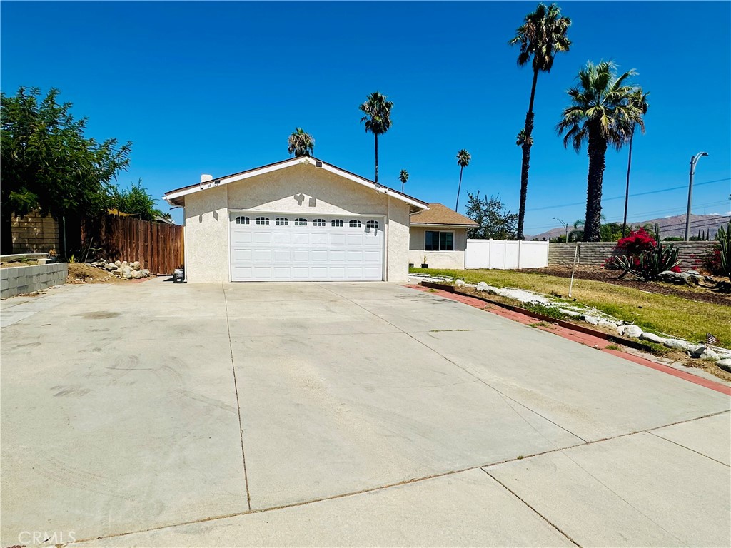 a view of a house with a yard and palm trees