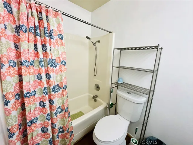 a white toilet sitting next to a bath tub