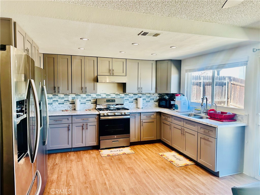 2111 Whitestone Drive Riverside, CA 92506 - Photo 8 of 29 a kitchen with stainless steel appliances granite countertop a stove refrigerator and cabinets