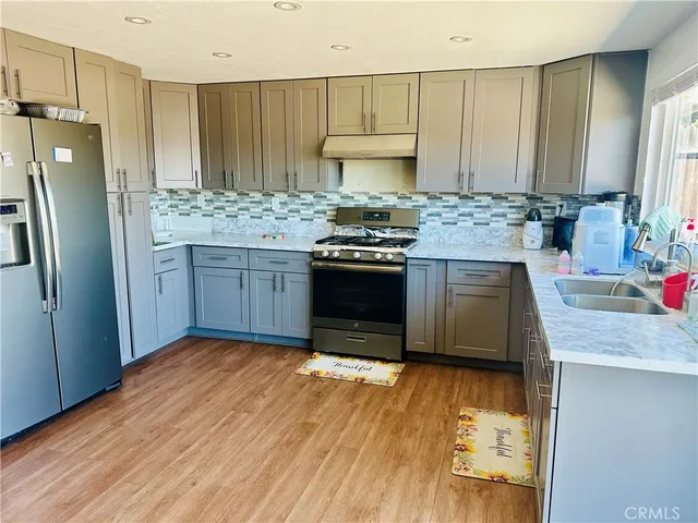 a kitchen with stainless steel appliances granite countertop a refrigerator stove and sink