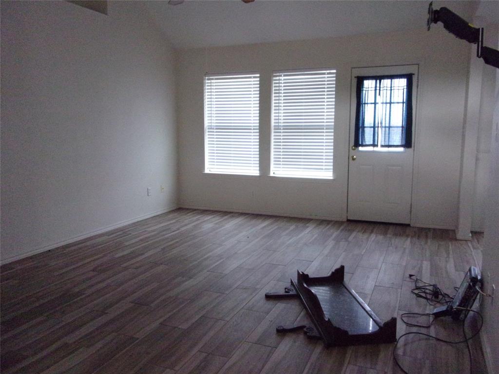 1511 Spanish Oak Drive Granbury, TX 76048 - Photo 2 of 16 an empty room with wooden floor and windows