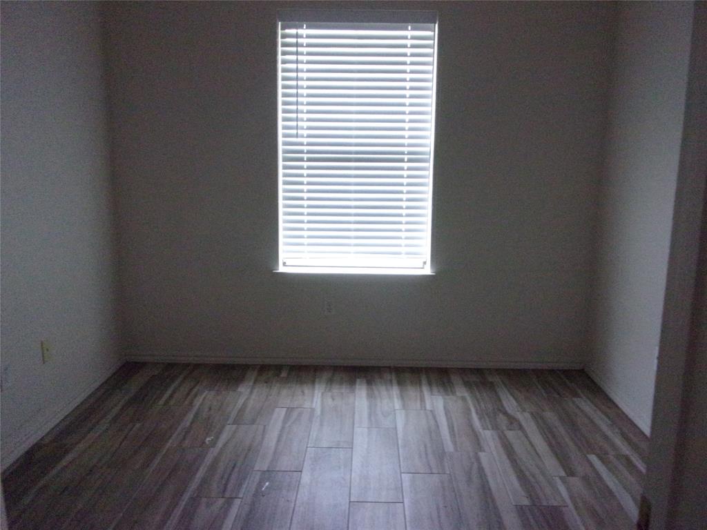 1511 Spanish Oak Drive Granbury, TX 76048 - Photo 3 of 16 an empty room with wooden floor and windows