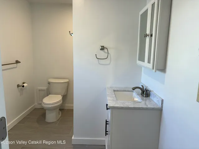 a bathroom with a toilet a sink and mirror