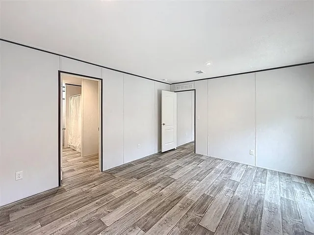 a view of an empty room with wooden floor