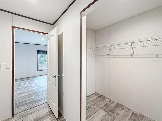 a view of a hallway with wooden floor and closet