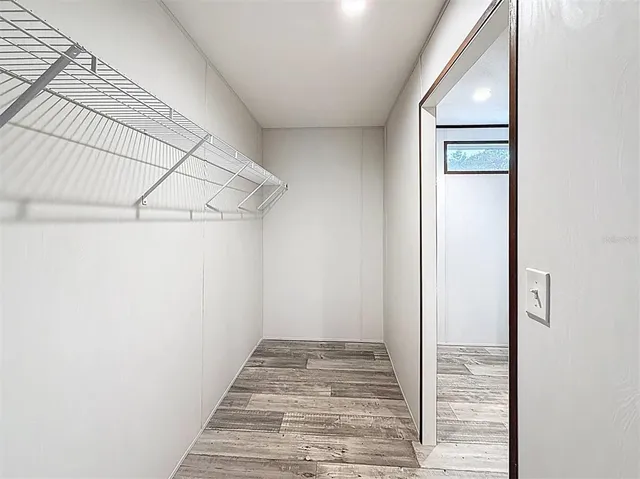 a view of a hallway with wooden floor and entryway