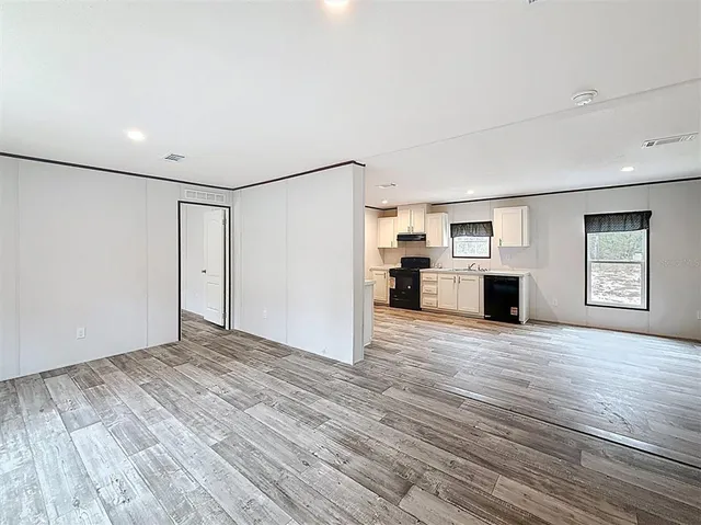 a view of empty room with wooden floor and fireplace