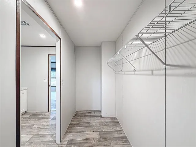 a view of a hallway with wooden floor and entryway