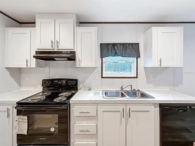 a kitchen with stainless steel appliances a stove a sink and a microwave