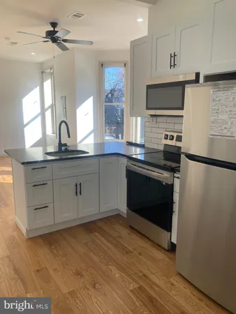 a kitchen with a sink cabinets stainless steel appliances and a window