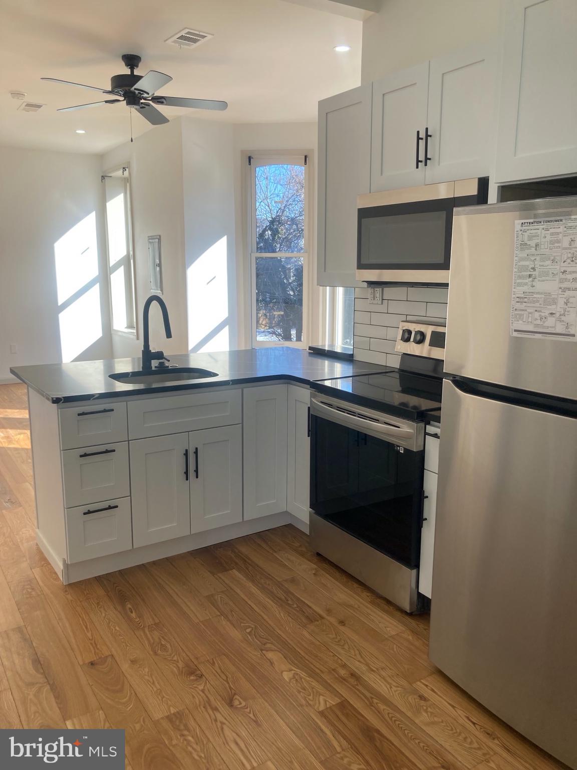 1901 West Diamond Street, Unit 2 Philadelphia, PA 19121 - Photo 5 of 9 a kitchen with a sink cabinets stainless steel appliances and a window