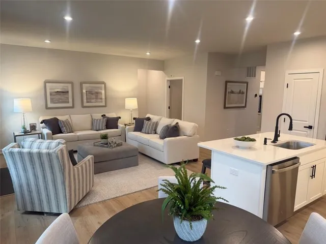 a living room with furniture potted plant and white walls