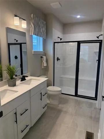 a bathroom with a double vanity sink toilet and shower