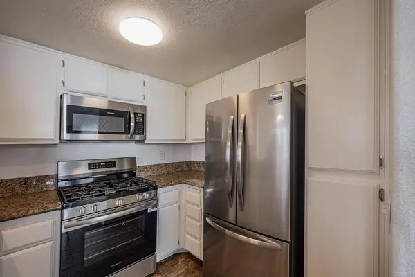 a kitchen with stainless steel appliances a refrigerator stove and microwave