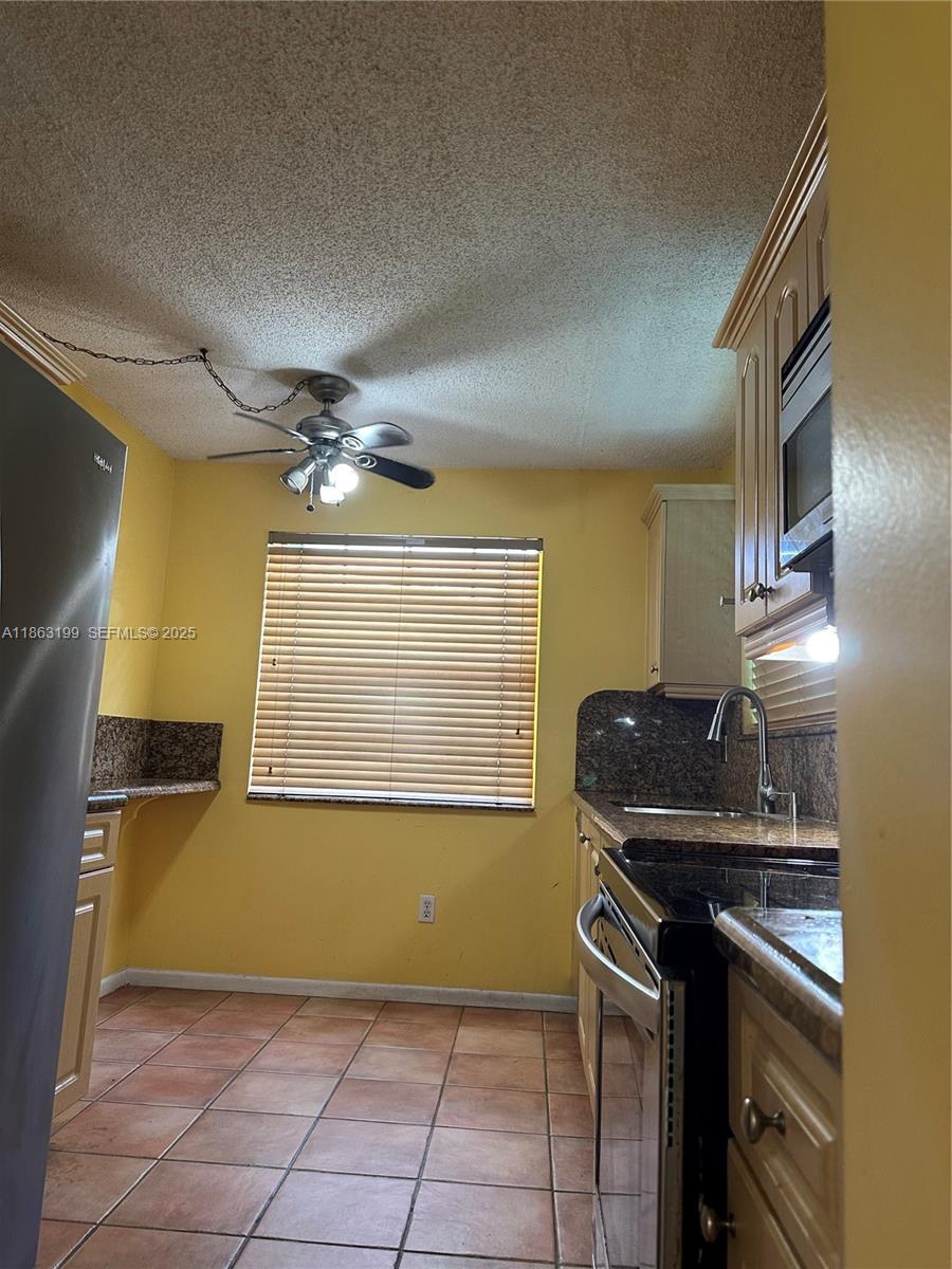 2653 Southeast 20th Court, Unit 105D Homestead, FL 33035 - Photo 15 of 16 a kitchen that has a sink and a stove