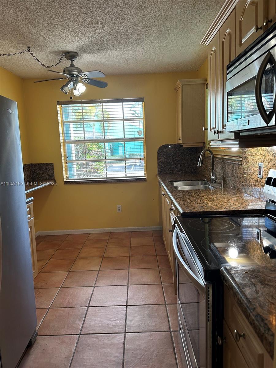 2653 Southeast 20th Court, Unit 105D Homestead, FL 33035 - Photo 16 of 16 a kitchen with a sink a stove cabinets and a counter top space