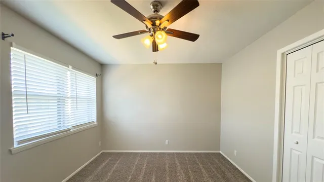a view of room with window and a ceiling fan